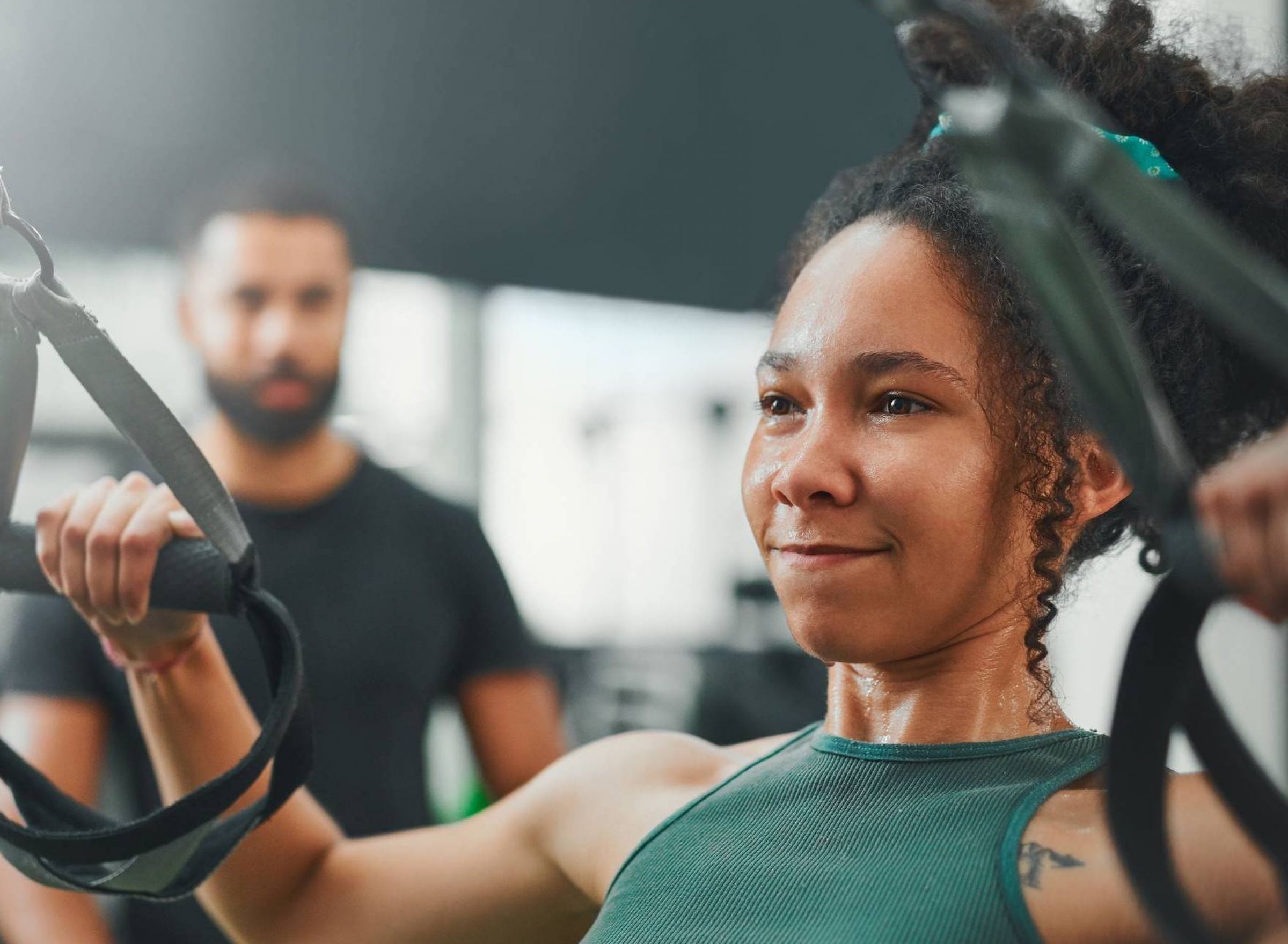 The Delta Pearland luxury apartments in Pearland, TX with a woman working out at a fitness center with a personal trainer