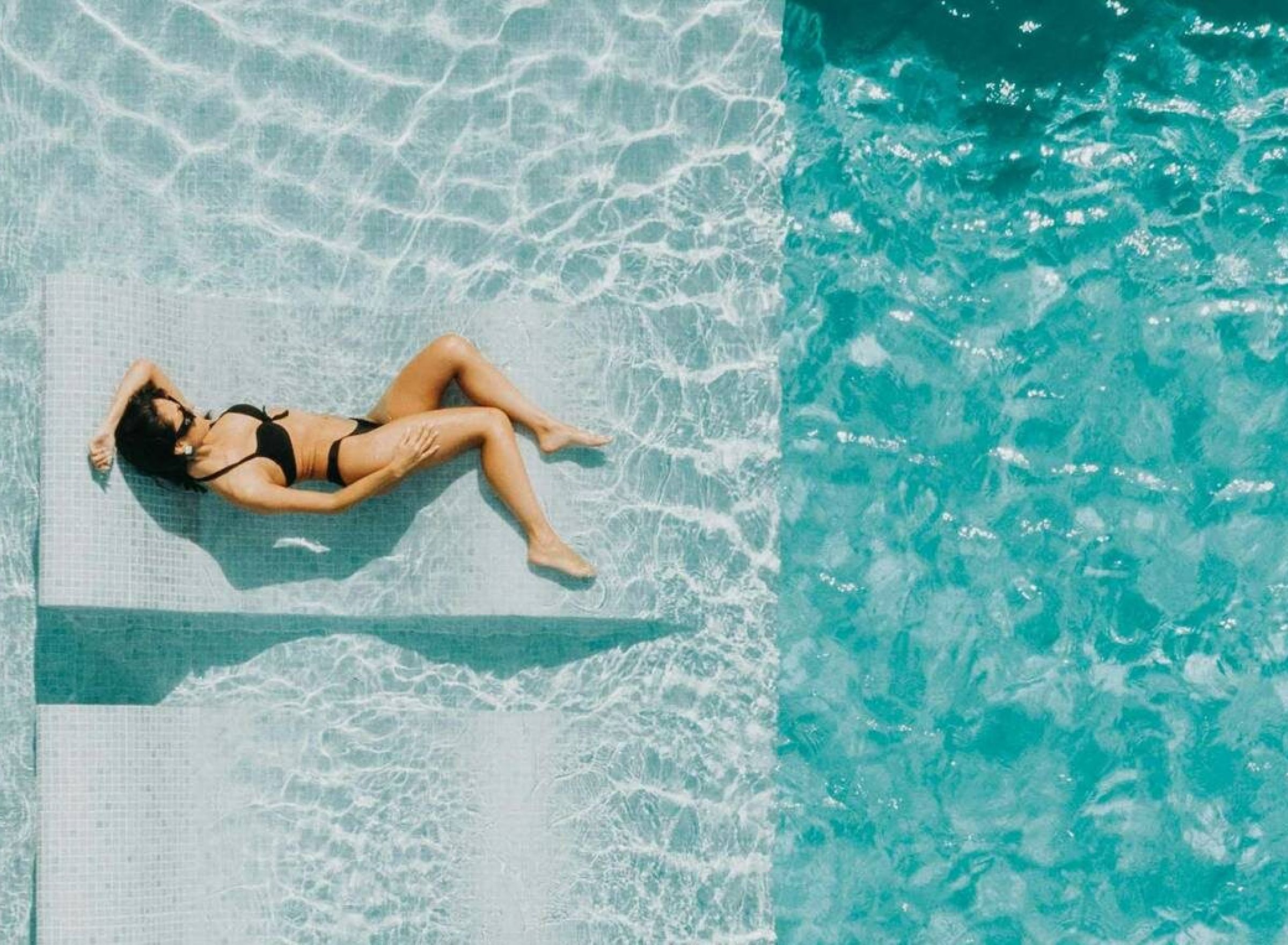 The Delta Pearland in Pearland, TX woman lounging on chair in the pool.