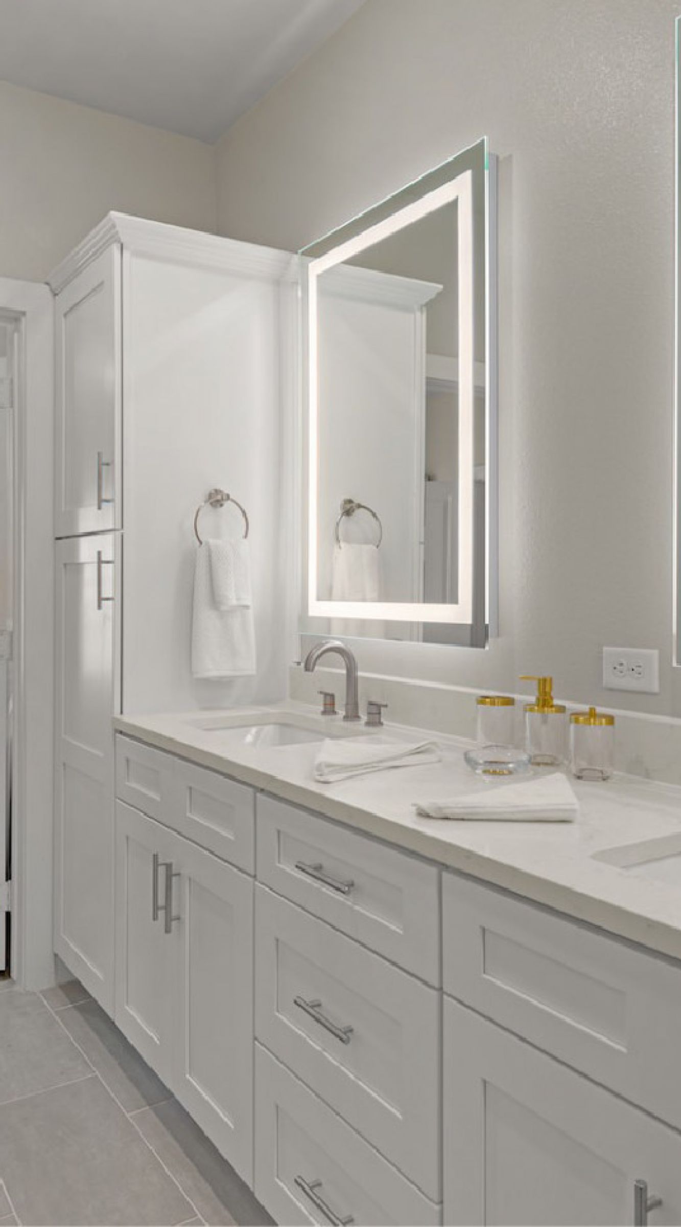 The Delta Pearland bathroom with LED backlit mirror and abundant cabinet storage space