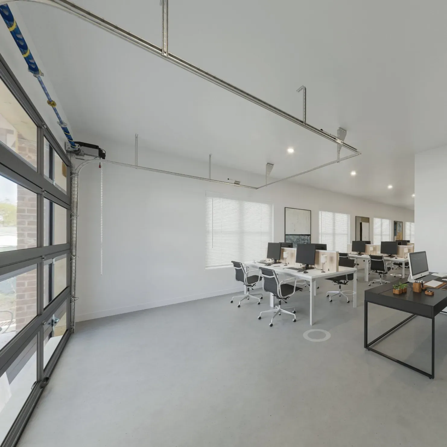 The Delta Pearland Live&Co Suites business and live spaces showing a modern office space with white desks, office chairs, computers, large windows, and a glass garage door.