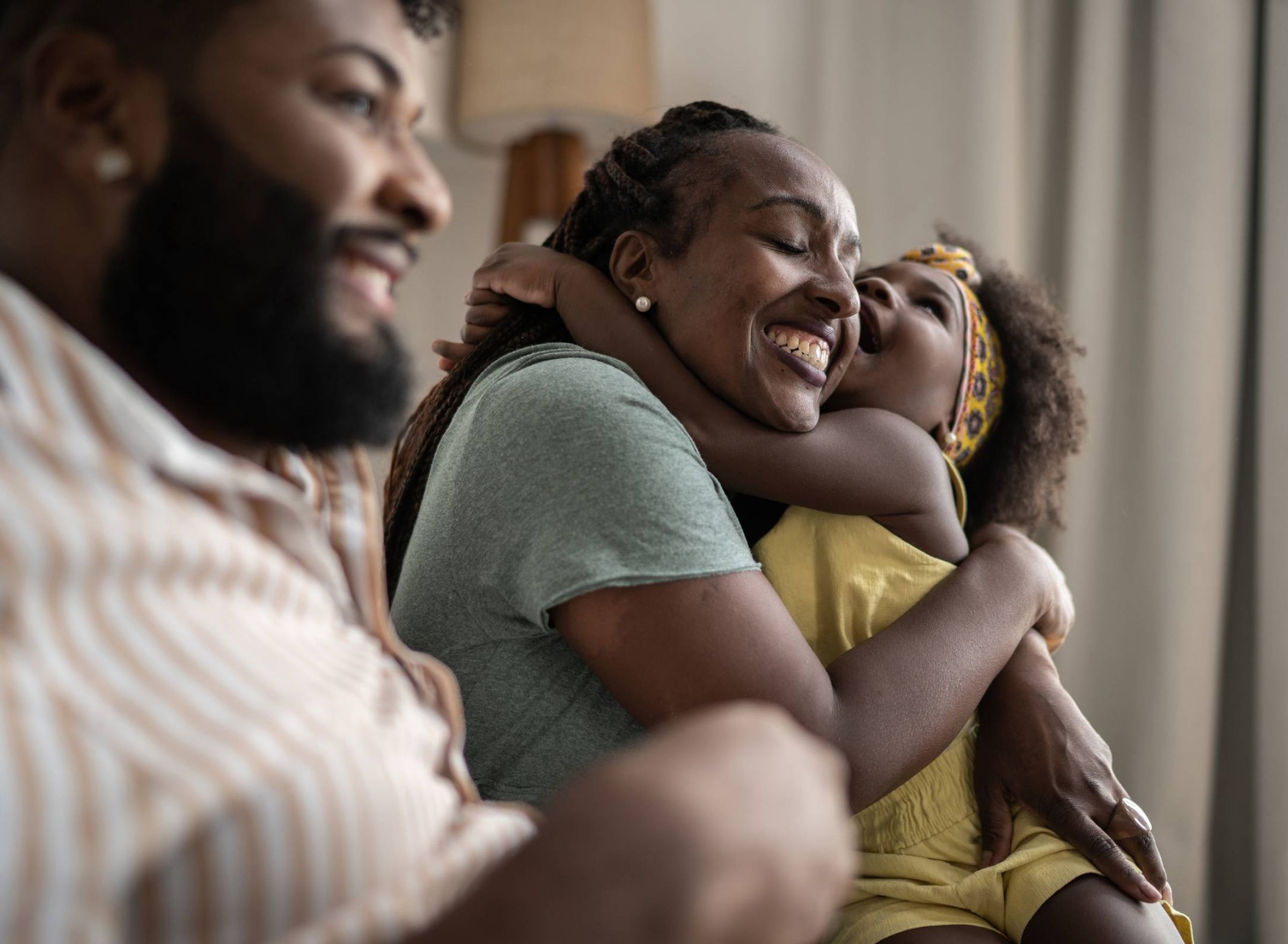 The Delta Pearland FAQs with a happy little girl embracing mother at home