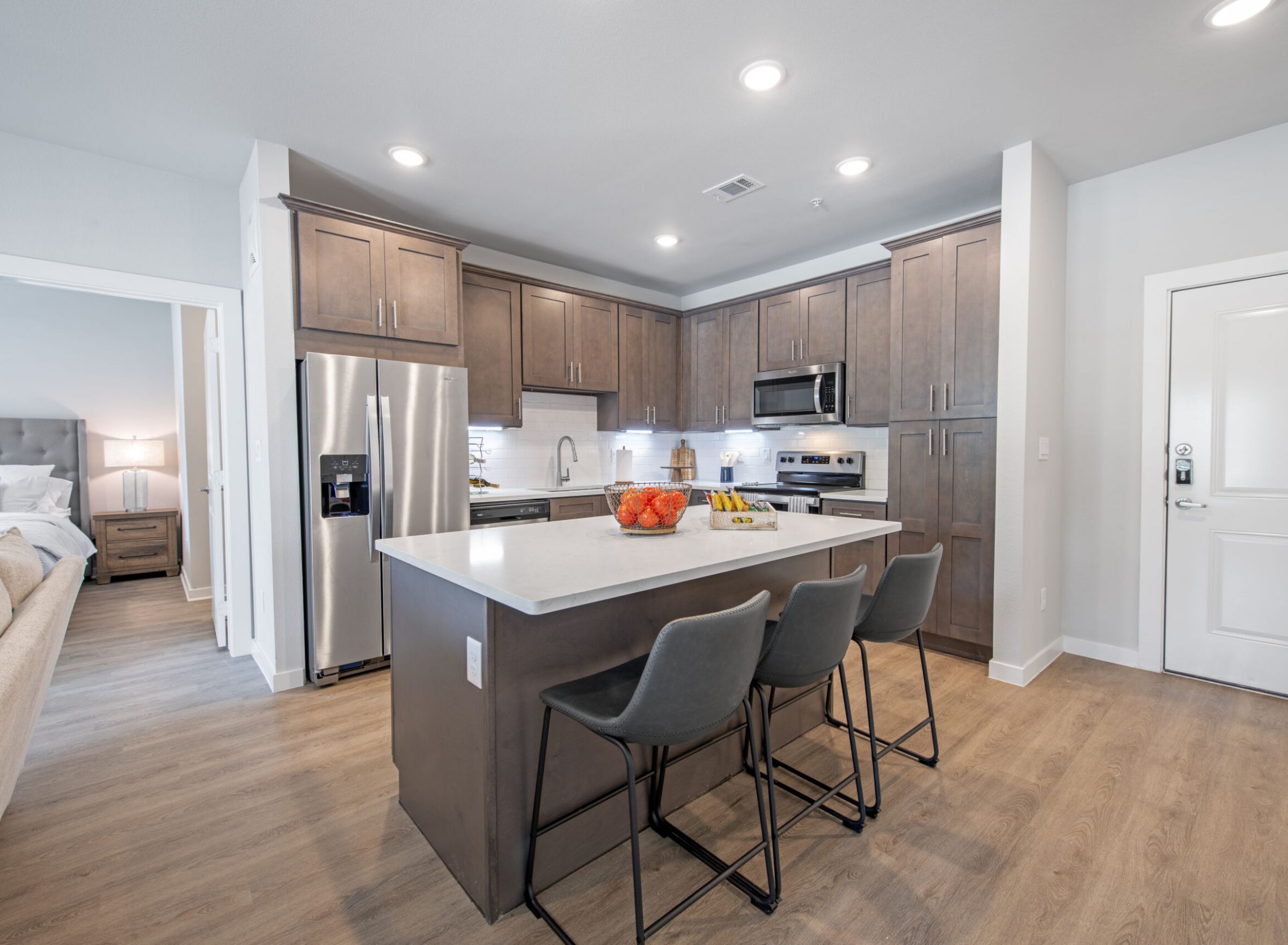 The Delta Pearland kitchen with kitchen island, bar chairs, floor-to-ceiling cabinets, and stainless steel appliances