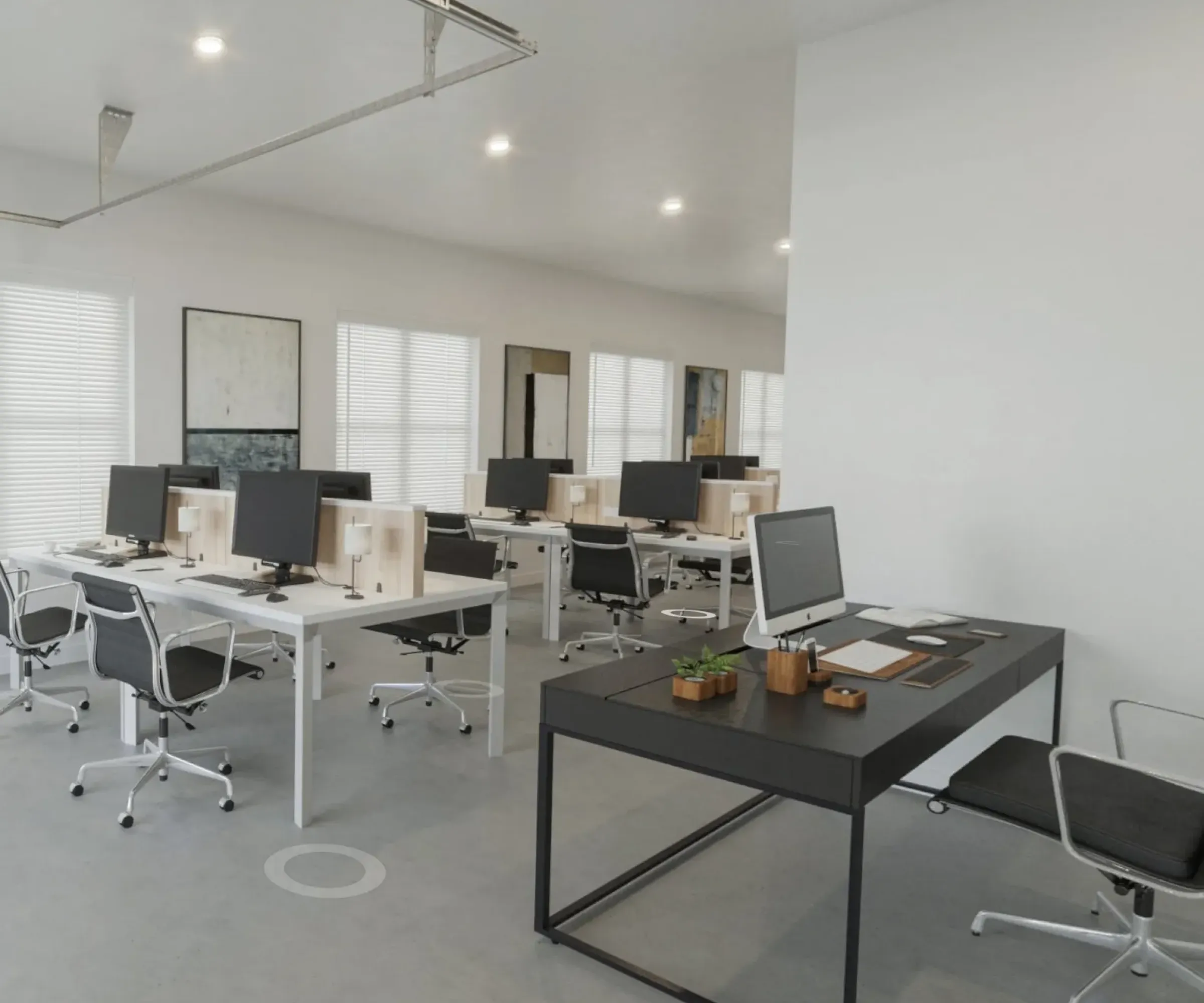 The Delta Pearland Live&Co Suites business and live spaces showing a modern open-plan office with several desks, computers, and chairs, featuring minimalist decor and bright lighting.